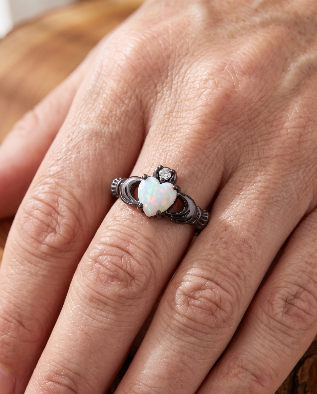 White Opal Claddagh Black Gold Ring worn on a model